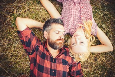 Yenilikçi ve kız yaz günü doğa keyfini çıkarın. Aşık çift yeşil çimenlerin üzerinde rahatla. Kadın uzun sarı saçlı ve sakallı adam. Yaz tatil kavramı. Aşk romantizm ve Aile