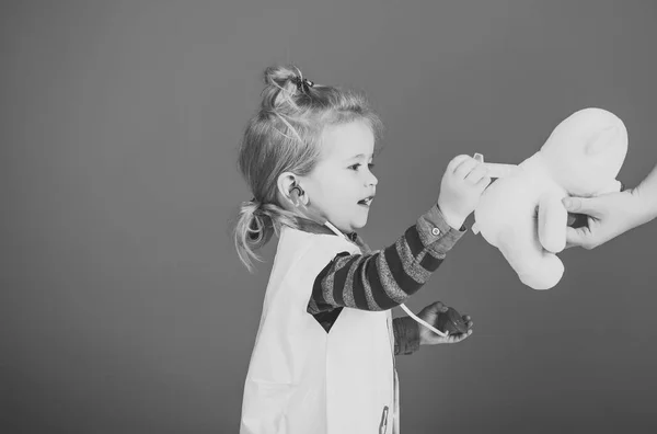 Chłopiec leczyć zabawka zwierzę szczepionką na niebieskim tle — Zdjęcie stockowe