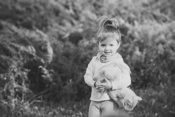 Mädchen mit stylischem Haar und Spielzeuglächeln auf natürlichem Hintergrund — Stockfoto