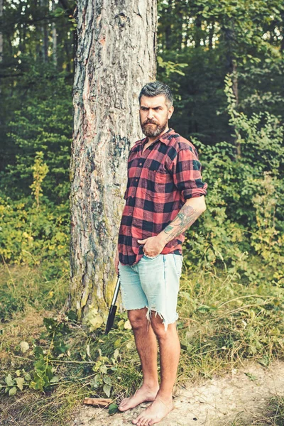 Bärtiger Hipster im Wald. Brutaler Holzfäller wartet auf dem Weg. Barfuß auf dem Boden stehend — Stockfoto