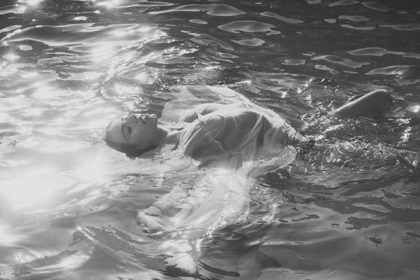 La ragazza in un vestito giallo si bagna in piscina — Foto Stock