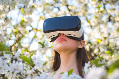 Oyun başladı. Sanal teknoloji simülasyonu. Bahar bahçe oyunda sevimli kız. Genç Bayan giyim vr gözlük Bahar Bloom. Sanal gerçeklik kulaklık güzel bir kız. Yenilikçi vr teknolojisi