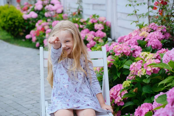 Giornata dei bambini. Piccola bambina. Fiori primaverili. L'infanzia. Estate. Festa delle madri o delle donne. Un nuovo concetto di vita. Vacanze primaverili. Ragazzina al fiore in fiore. Ragazza felice. Buon giorno di primavera — Foto Stock