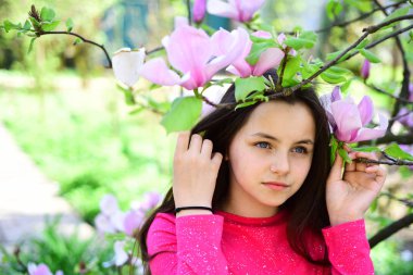 Bir bahar o. Sevimli kız bahar peyzaj sakin ol. Sevimli kız oyun çiçek açması çiçeklerle parkta. Çiçeklenme tree yakınındaki güzel kız Manolya Çiçeği tadını çıkarın. Bahar zamanı