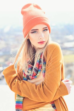 Turuncu şapka ve soyulmuş çok renkli atkı poz açık havada giyen düz sarı saçlı genç hippi. Sokak moda kavramı