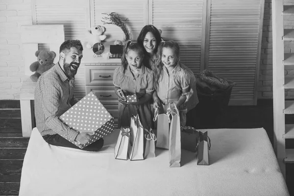 Mann, Frau und entzückende Kinder mit Geschenken zu Hause — Stockfoto