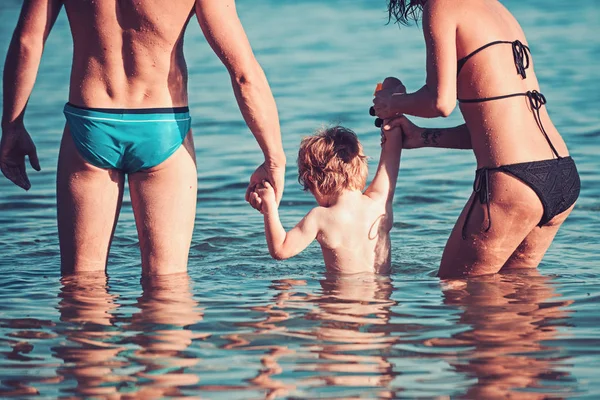 Rilassarsi in vacanza estiva. relax di giovane famiglia con bimbo piccolo in acqua di mare . — Foto Stock
