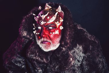 Beyaz sakallı komuta sizde canavar gibi giyinmiş. Uzaylı, iblis büyücü makyaj. Kötü kavramı. Siyah zemin üzerine kırmızı yüz şeytanla kapatın. Dikenler veya siğiller kürk paltolu adam.