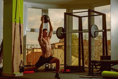 Spor ve spor salonu konsept. Sporcu, atlet, kas maço mu egzersiz trx döngüler ve sağlık topu, pencere arka plan ile. Adam çıplak gövde içinde jimnastik salonu ile eğitim, trx zevk.