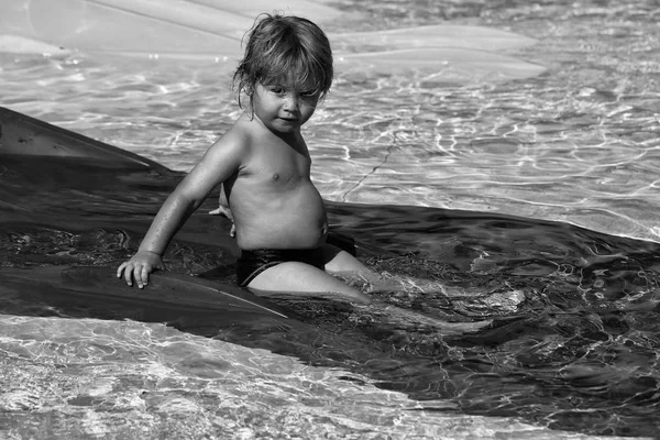 Bonito menino desliza a partir de laranja waterslide — Fotografia de Stock