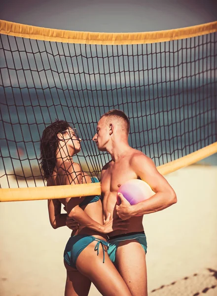 Mujer sexy y hombre musculoso con bola en la red. sexy mujer o chica coqueteando con el hombre muscular celebración de la bola en la red . —  Fotos de Stock