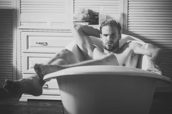 Handsome young man in bathtub at home having bath — Stock Photo, Image