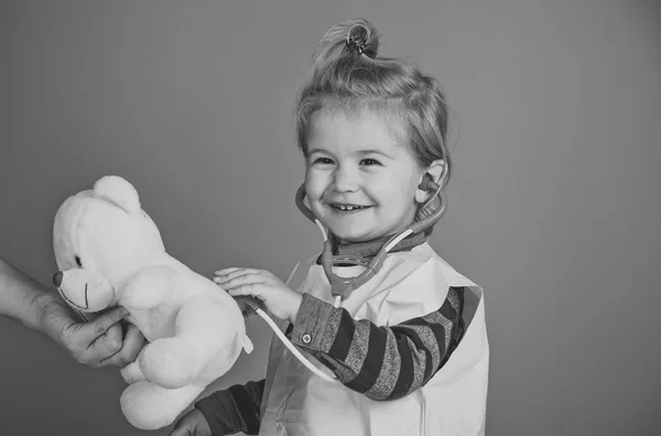 Lycklig pojke spela veterinär med Nalle i mödrar hand — Stockfoto