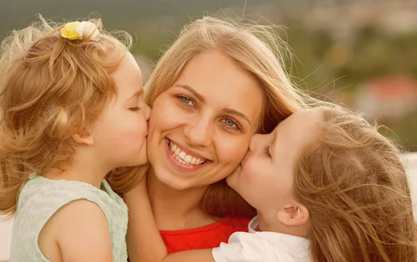 Filles embrasser mère sur paysage naturel — Photo