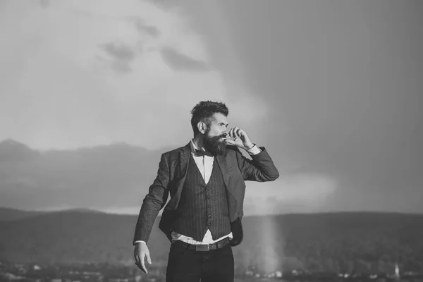Hipster con aspecto elegante fumar en frente del cielo —  Fotos de Stock