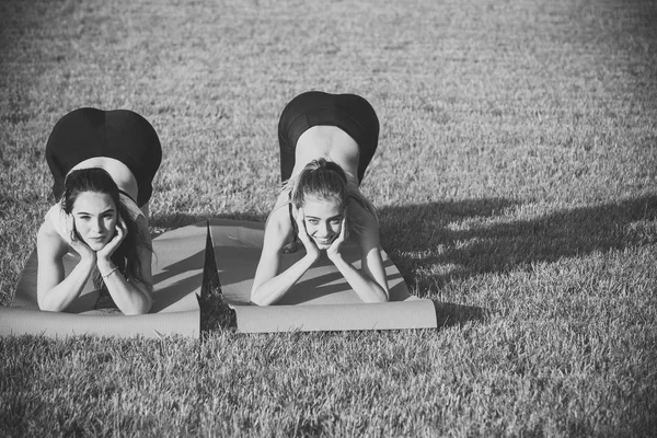 体育妇女训练在瑜伽垫在绿色草 — 图库照片