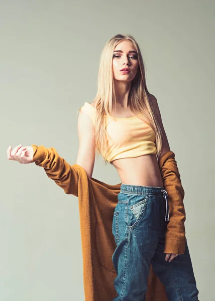 Menina loira com cabelo liso vestindo jeans estilo namorado e top amarelo isolado no fundo cinza — Fotografia de Stock