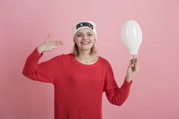 Change your mindset. A genius idea came into her head. Happy woman hold light bulb gesturing finger gun. Sensual woman wear hat with genius word. Girl genius got bright idea