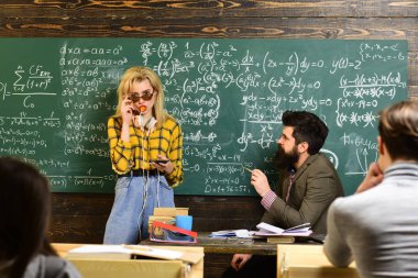 Öğretmen raporları yetenekli öğrencilerin hataları düzeltmek gönüllülük gözlük. Özenli öğrenciler bir şey onların Not pads, masaları sınıfta otururken yazma.