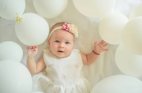 Was sonst noch zu tun ist. süßes kleines Baby. neues Leben und Geburt. Kinderglück. kleines Mädchen. Alles Gute zum Geburtstag. Familie. Kinderbetreuung. Kindertag. Porträt eines glücklichen kleinen Kindes in weißen Luftballons — Stockfoto