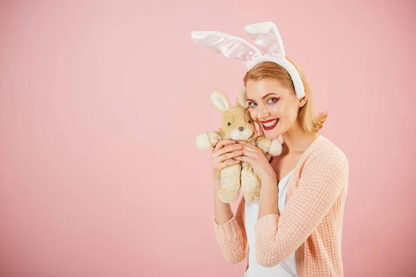 Щаслива жінка в кролячих вухах з іграшкою. Весняне свято. Дівчина з іграшкою-заєць. Щасливого Великодня. Полювання на яйце. Пасхальні яйця як традиційна їжа. Жінка в кролячих вухах. копіювання простору. Великодні сюрпризи — стокове фото