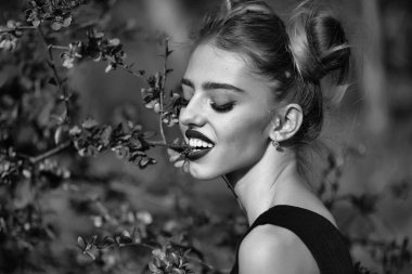 Kırmızı bahar çiçeği parkta güzel bir kadın. Güzellik ve moda, doğa