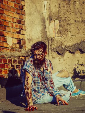 Zombi adam asfalt üzerinde oturur