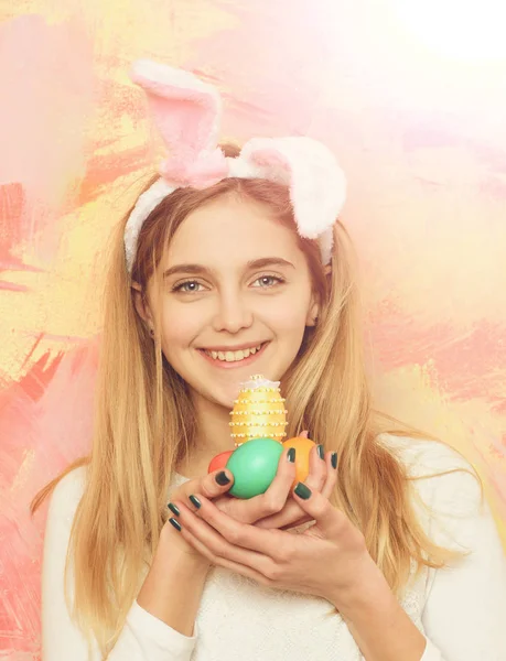 Feliz chica de Pascua en orejas de conejo con coloridos huevos pintados — Foto de Stock