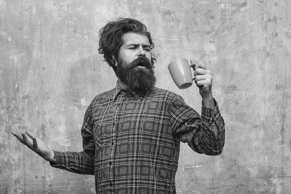 Поющий бородатый мужчина тянет стильные бахромые волосы с голубой чашкой — стоковое фото