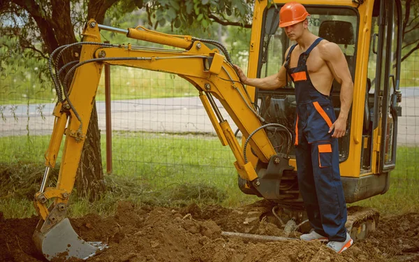 Concepto de excavación. Excavadora operada por el hombre para excavación en tierra. El operador de excavadoras trabaja en el sitio de excavación. Excavación y construcción — Foto de Stock