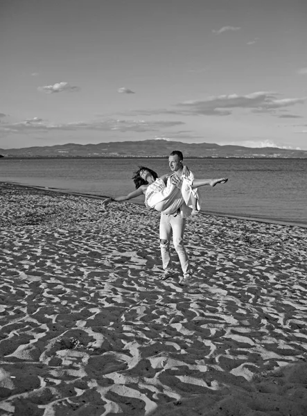 Mulher sexy e homem no mar. Dia da família e dos namorados. As relações de amor do par que gosta do dia de verão em conjunto. Casal apaixonado relaxar na areia da praia. Férias de verão e férias de viagem — Fotografia de Stock