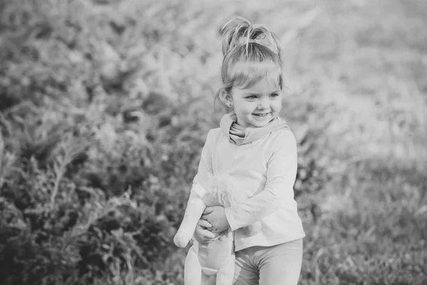 Happy girl with soft toy smile on natural background — Stock Photo, Image