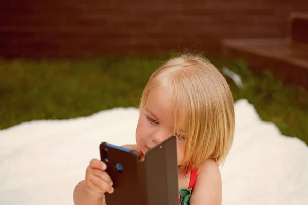 Excellente capacité de communication. Petite fille avec téléphone portable. Enfant fille aux cheveux blonds parler sur téléphone portable. Nouvelles technologies pour les enfants. Un petit enfant passe un coup de fil. Mes cheveux mon regard — Photo