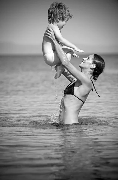 Famiglia felice sul mare dei Caraibi. madre con figlio nuotare in acqua. Vacanze estive e viaggi verso l'oceano. Maldive o Miami spiaggia attività gioia. Festa di giorno di madri di bambino in mani di genitore di donna . — Foto Stock