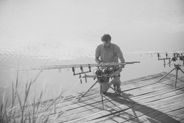 Man fix equipamento de pesca no cais de madeira — Fotografia de Stock