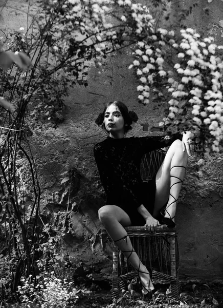 橘园，坐在藤椅上的黑色，花边礼服的女人 — 图库照片