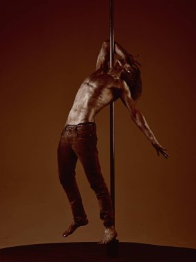 Güçlü dansçı egzersiz kutup. Özgürlük. Pilon üzerinde dans gümüş gövde sanat kaslı adam. Pole dans spor. Metal yüzey ile seksi maço. Atletik adam olun akrobatik öğeleri pilon üzerinde.