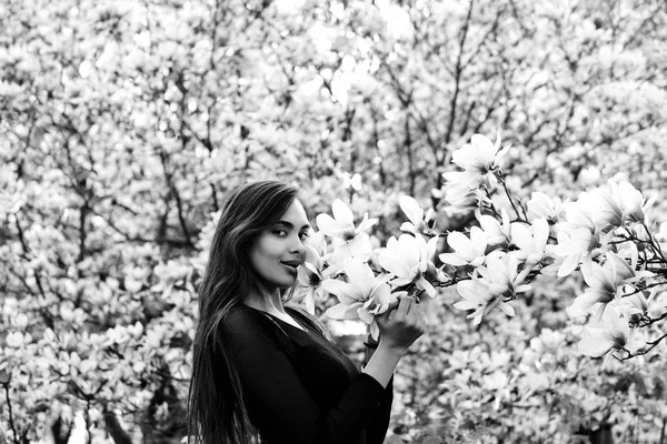 Mulher com cabelo longo e morena posando na árvore de magnólia — Fotografia de Stock