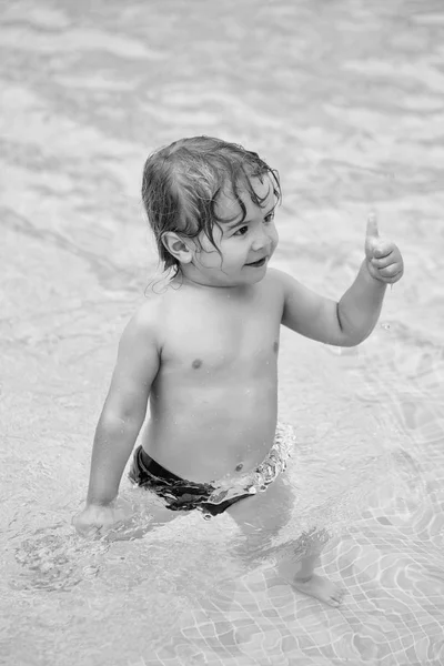 Симпатичный веселый мальчик показывает большие пальцы вверх жестом — стоковое фото