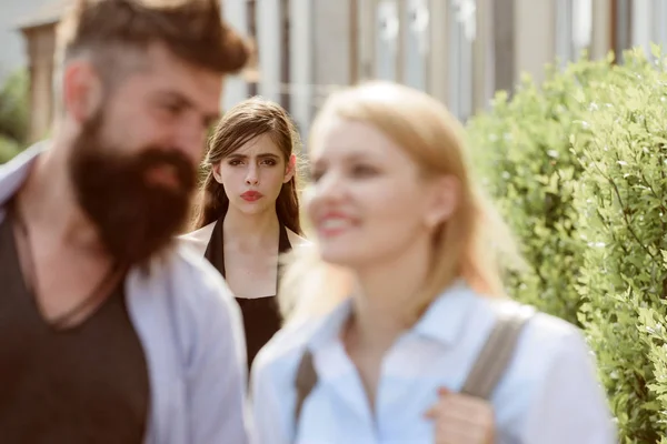 Terribly jealous of them. Romantic couple of man and woman dating. Bearded man cheating his girlfriend with another woman. Jealous woman look at couple in love on street. Unhappy girl feeling jealous — Stock Photo, Image