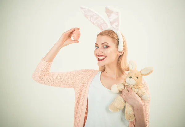 Gelukkige vrouw in bunny oren met speelgoed. Vrouw in konijn bunny oren. Vrolijk Pasen. Voorjaar vakantie. Meisje met Haas speelgoed. Egg hunt. Paaseieren als traditionele gerechten. Opgewonden gevoel — Stockfoto