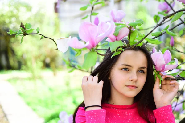 Le printemps est là. Adorable fille jouer dans le parc avec des fleurs florissantes. Jolie fille se détendre sur le paysage de printemps. Jolie fille près de l'arbre à fleurs profiter de la fleur de magnolia. Son printemps — Photo