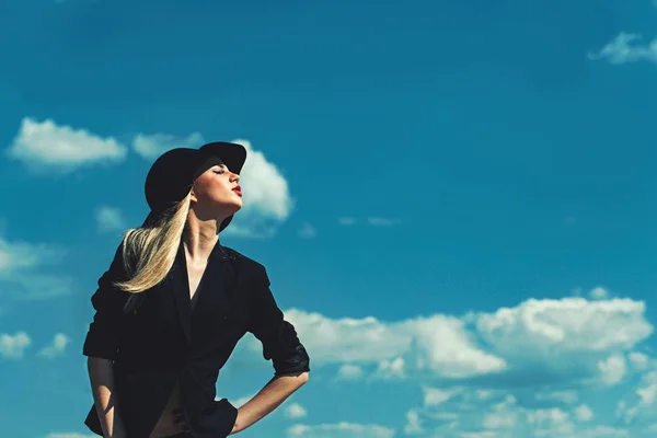 Meisje op zonnige blauwe hemelachtergrond, kopie ruimte. meisje in zwarte elegante retro hoed en rode lippen. — Stockfoto