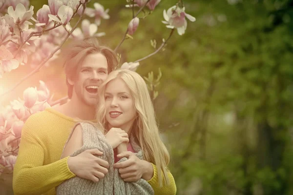Man met meisje of mooie vrouw op bloeiende magnolia — Stockfoto