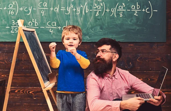 Kind trägt ein Gedicht vor, während der Lehrer aufmerksam zuhört. Cooler Typ im rosa Hemd, der auf dem Boden neben dem stehenden Kind sitzt. Zurück zur Schule — Stockfoto