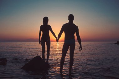 Tatil kaç gün batımı kumsalda birlikte yürüyüş el ele tutuşarak seviyorum. Mutlu genç çift, kadın ve beyaz adam