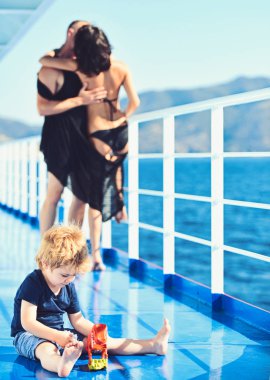 Mutlu bir aile tatil yaz. Sevgi ve güven aile değerleri olarak. Anne ve baba ile oğlu deniz gezisinde. Çocuk Anne ve baba, oyuncaklarla oynamak. Aile Anne ya da babalar gününde çocukla seyahat
