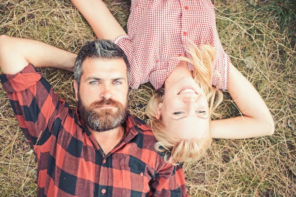 Бородатий чоловік і жінка з довгим світлим волоссям в літній день. Пара закоханих відпочиває на зеленій траві. Хіпстер і дівчинка насолоджуються природою. Концепція літніх канікул. Любов романтика і сім'я — стокове фото