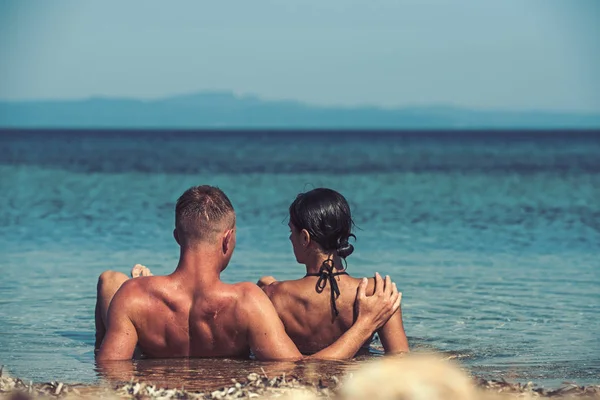 Sommerferien und Urlaub auf Reisen. Liebesbeziehungen von Paaren, die gemeinsam den Sommertag genießen. Familien- und Valentinstag. sexy Frau und Mann schwimmen im Meerwasser. Verliebte Paare entspannen sich am Strand. — Stockfoto