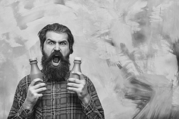 Θυμωμένος γενειοφόρο άτομο που κρατά δύο πλαστικά μπουκάλια — Φωτογραφία Αρχείου